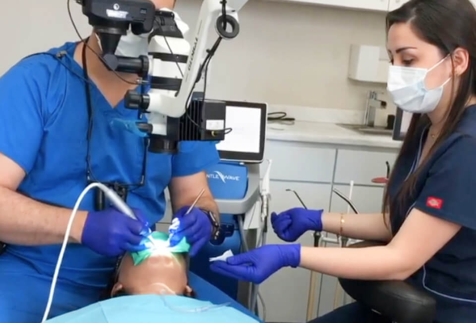 Picture of Dr. Maz Ebrahimi and his assistant working on a patient