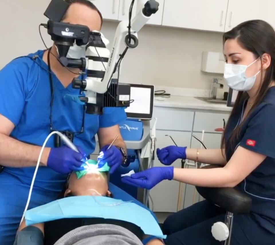 Picture of Dr. Maz Ebrahimi and his assistant working on a patient